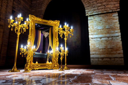 golden baroque mirror with a gold candelabrum