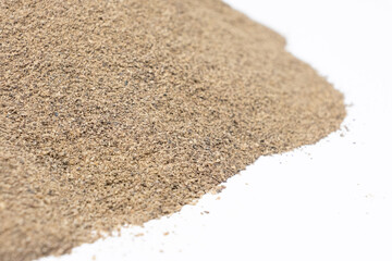 Spilled ground black pepper spicy seasoning on a white background
