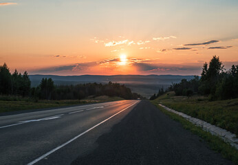 Sun setting over countryside road