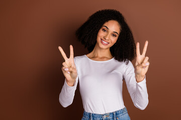 Photo of pretty young girl show v-sign wear pullover isolated on brown color background