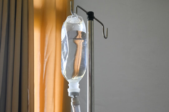 Infusion bottle with IV solution. saline bag hanging on stainless pole. 