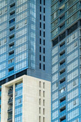 A partial close-up of a high-rise building in a narrow space in the city.