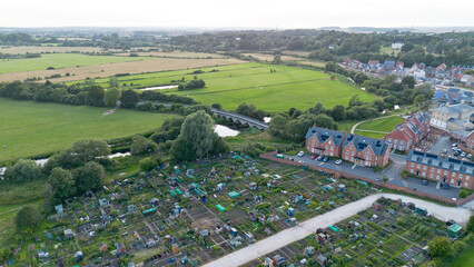  aerial view of allotments, new build houses and distant country house