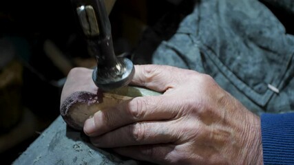 Bootmaker drive in nails in a shoe at the private workshop. Shoe making process