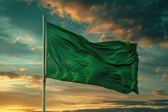 A green flag blowing in the wind during a beautiful sunset