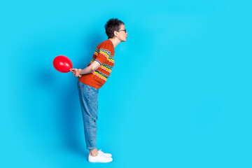 Full size profile photo of nice aged woman hide balloon empty space wear t-shirt isolated on blue color background