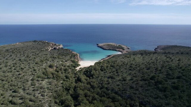 Aerial view of tranquil bay with azure water and sandy beach, Cala Varques, Mallorca, Spain.