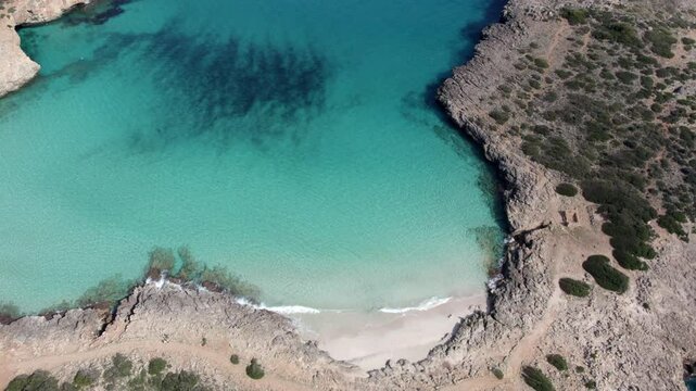 Aerial view of turquoise water and rocky coast in Cala Varques, Mallorca, Spain.