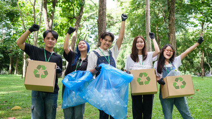 Group of volunteers are celebrating the completion of a community project together in the park. Community, environmental protection and recycling concept.