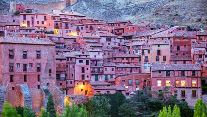 Detail of the historical artistic complex of the town of Albarracin, Teruel, Aragon, Spain, illuminated at dusk, with its typical medieval buildings with reddish facades © AntonioLopez
