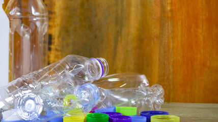 Waste plastic bottles on wooden background waiting for recycling concept of saving our environment sustainable natural resources.