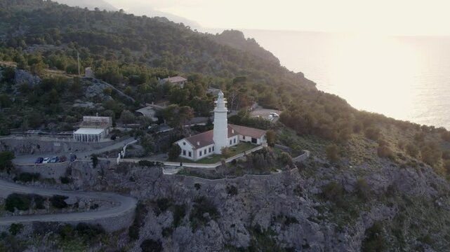 Aerial view of serene sunset over lighthouse, cliff, and coast in Soller, Mallorca, Spain.