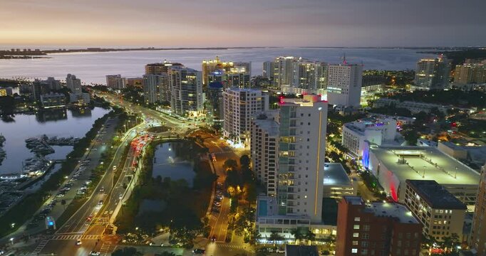 Aerial view of Sarasota city downtown at night with high-rise office buildings and Ringling Bridge on horizon. Real estate development in Florida. USA travel destination.