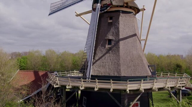 Aerial view of traditional windmill surrounded by tulips in spring, t Zand, Netherlands.