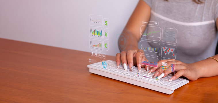 security and investment concepts on the web. close-up of a woman's hands on a computer keyboard managing international investments. holograms and graphics of international investment and currency