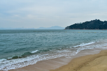 Close-up of soft waves sand beach and blue sea. Texture of water, white foam waves. Seascape, Sea background, Sea water with copy space, summer vacation concept. 