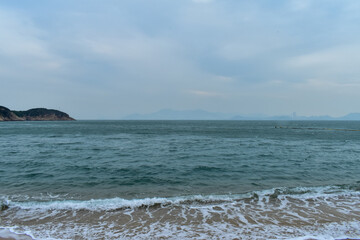 Close-up of soft waves sand beach and blue sea. Texture of water, white foam waves. Seascape, Sea background, Sea water with copy space, summer vacation concept. 