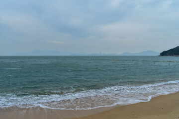 Close-up of soft waves sand beach and blue sea. Texture of water, white foam waves. Seascape, Sea background, Sea water with copy space, summer vacation concept. 