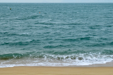 Close-up of soft waves sand beach and blue sea. Texture of water, white foam waves. Seascape, Sea background, Sea water with copy space, summer vacation concept. 