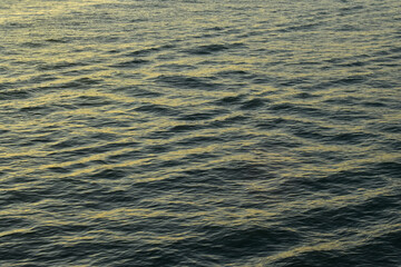 Reflection of golden sunlight on water. Sunset sea view with sparkle sunlight. Sunset light hitting on the ocean. Sunset sea background.