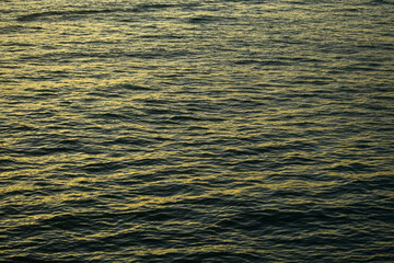 Reflection of golden sunlight on water. Sunset sea view with sparkle sunlight. Sunset light hitting on the ocean. Sunset sea background.