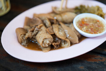 Stewed pork intestine served with seafood dip on pink dish