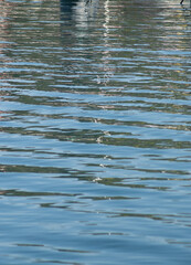the water reflection of several boats in a sea port