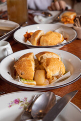 Escabeche sandwich Peruvian breakfast food table with lomo saltado and pejerrey sandwich