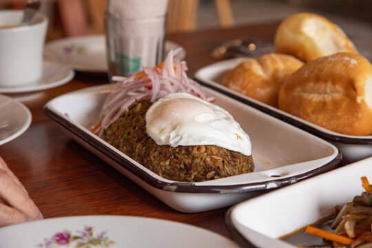 Tacu tacu with fried egg Peruvian breakfast food table with lomo saltado and pejerrey sandwich