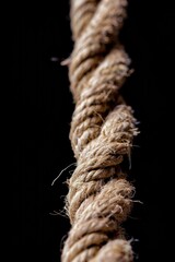 A detailed view of a rope against a dark background, suitable for abstract or minimalist designs