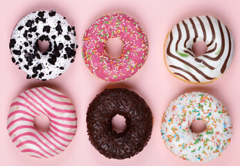 donuts with colored glaze on a pink background