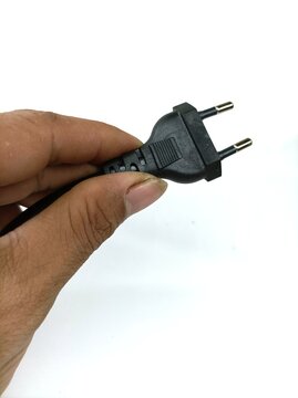 Hand hilding aEU plug power supply isolated on white background.