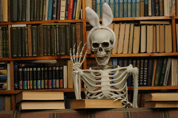 
Human skeleton with rabbit ears. Bookshelves with books.