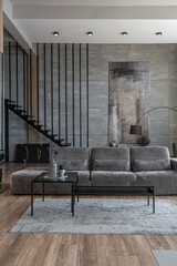 stylish minimalistic restrained modern interior of a two-storey apartment without people in the daytime in loft style in gray tones.