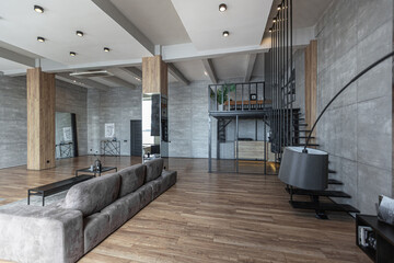 stylish minimalistic restrained modern interior of a two-storey apartment without people in the daytime in loft style in gray tones.