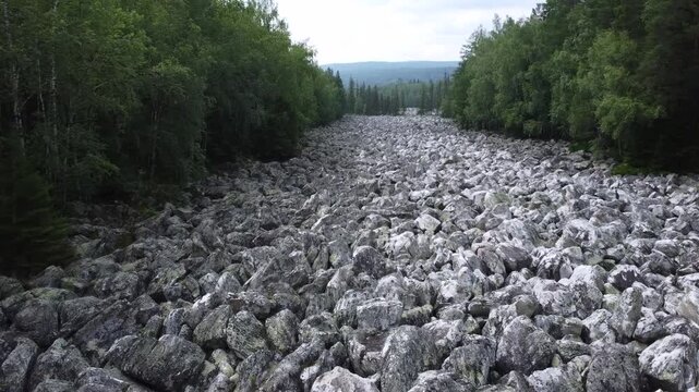 Big stone river in South Ural / kurumnik place of difficult hiking, active lifestyle, explore and discover concept in rocky valley. Aerial drone wide shot at summer sunny day