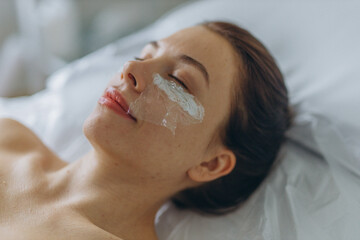 A professional beautician injects into the face of a young woman