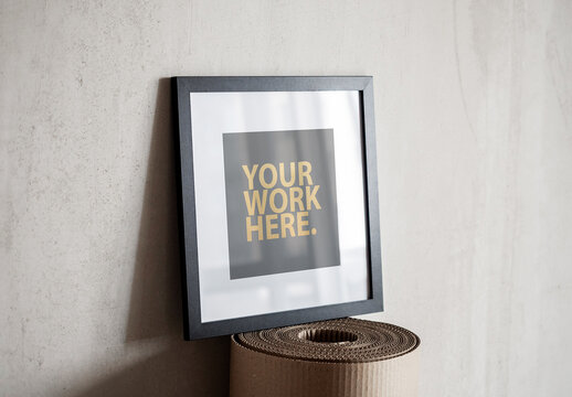 Square poster black frame with passepartout mockup standing on a cardboard roll