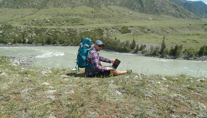 hiker freelancer with laptop in the countryside