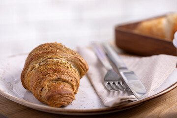 A delicious Zaatar croissant, showcasing its flaky, golden-brown crust sprinkled with aromatic zaatar seasoning. Perfectly baked, this Middle Eastern twist on a classic pastry offers a unique flavor