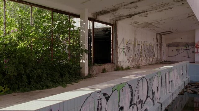 Aerial view of abandoned hotel with swimming pool and graffiti, Kupari, Dubrovnik-Neretva, Croatia.