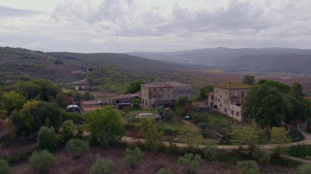Aerial view of tranquil countryside with olive trees and rustic houses, Murlo, Tuscany, Italy.