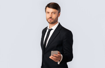Call Me Concept. Businessman Holding Mobile Phone Standing Over White Studio Background. Empty Space, Isolated