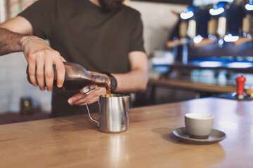 The process of coffee preparation by a specialist in coffee. A variety of coffee. barista is pouring Cold brew coffee at counter in jug. Pouring icy cold brew from the bottle into jug