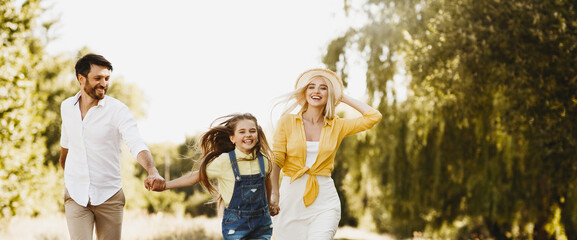 Fototapeta premium Joyful Summer. Family Running On Sunny After-Quarantine Day Outdoors Spending Time Together In Countryside. Panorama, Copy Space
