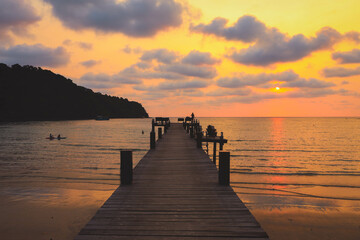 Obraz premium Wooden bridge towards to the sea at sunset, Thailand. Travel and Holiday concept.
