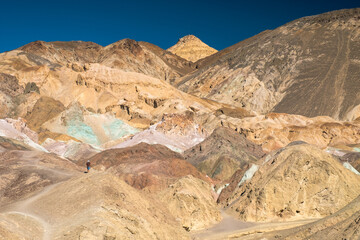 A person is walking on a mountain with a beautiful view of the sky