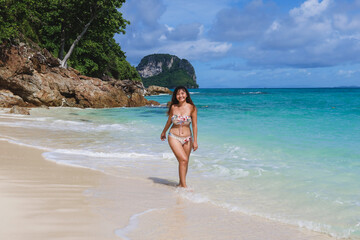 Asian young slim beautiful woman Running on The Beach. playful, running, bikini outfit, sunny, having fun, positive mood, splashing water, happy. Portrait young asian woman relax smile leisure