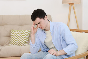 Fototapeta premium Sad man suffering from headache at home