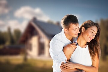 Happy smiling family couple standing outside house